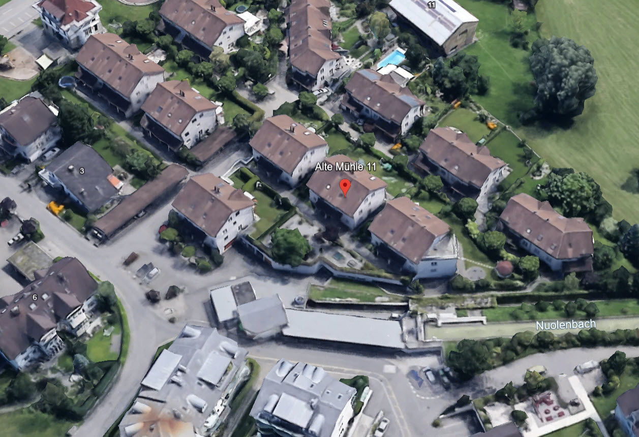 Aerial view of Alte Mühle 11, a house in a residential neighborhood with several other houses and buildings.