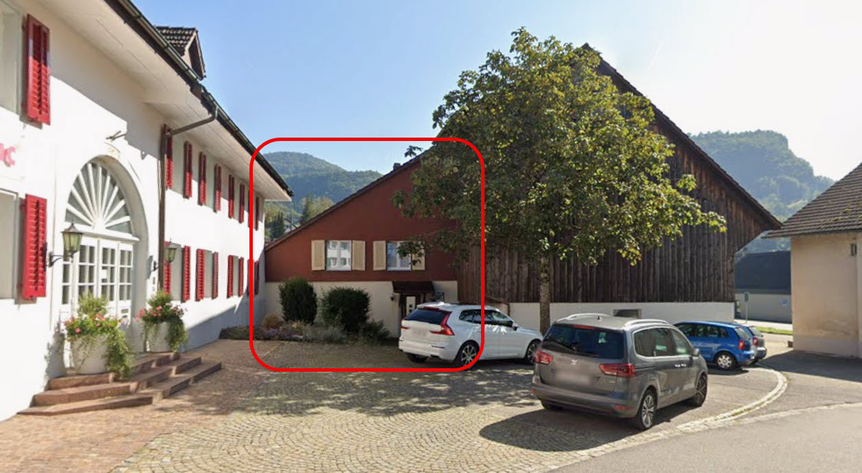 two story residential building, red brick walls, red shutters, parking