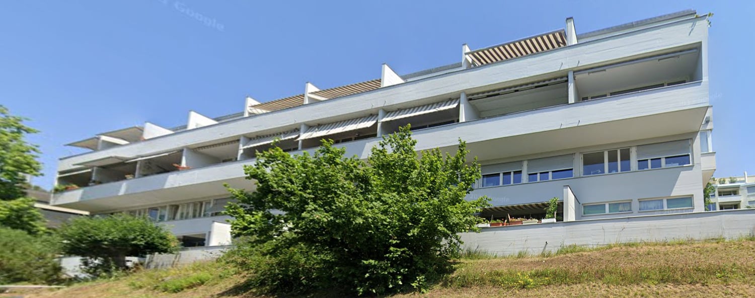 multi-story building, white exterior, multiple balconies, modern design