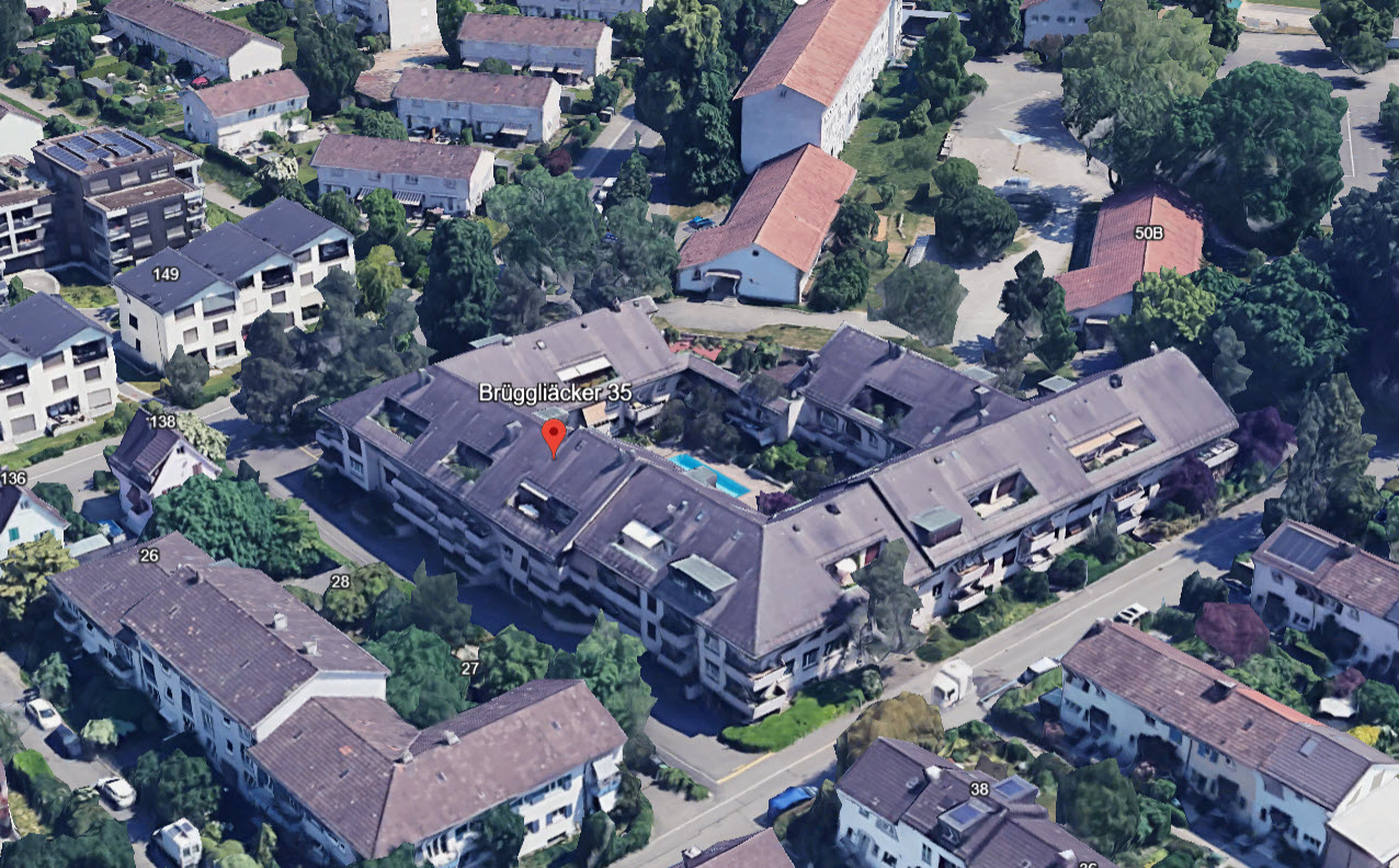 Apartment complex with several buildings, swimming pool, solar panels, multiple garages, and a parking lot.