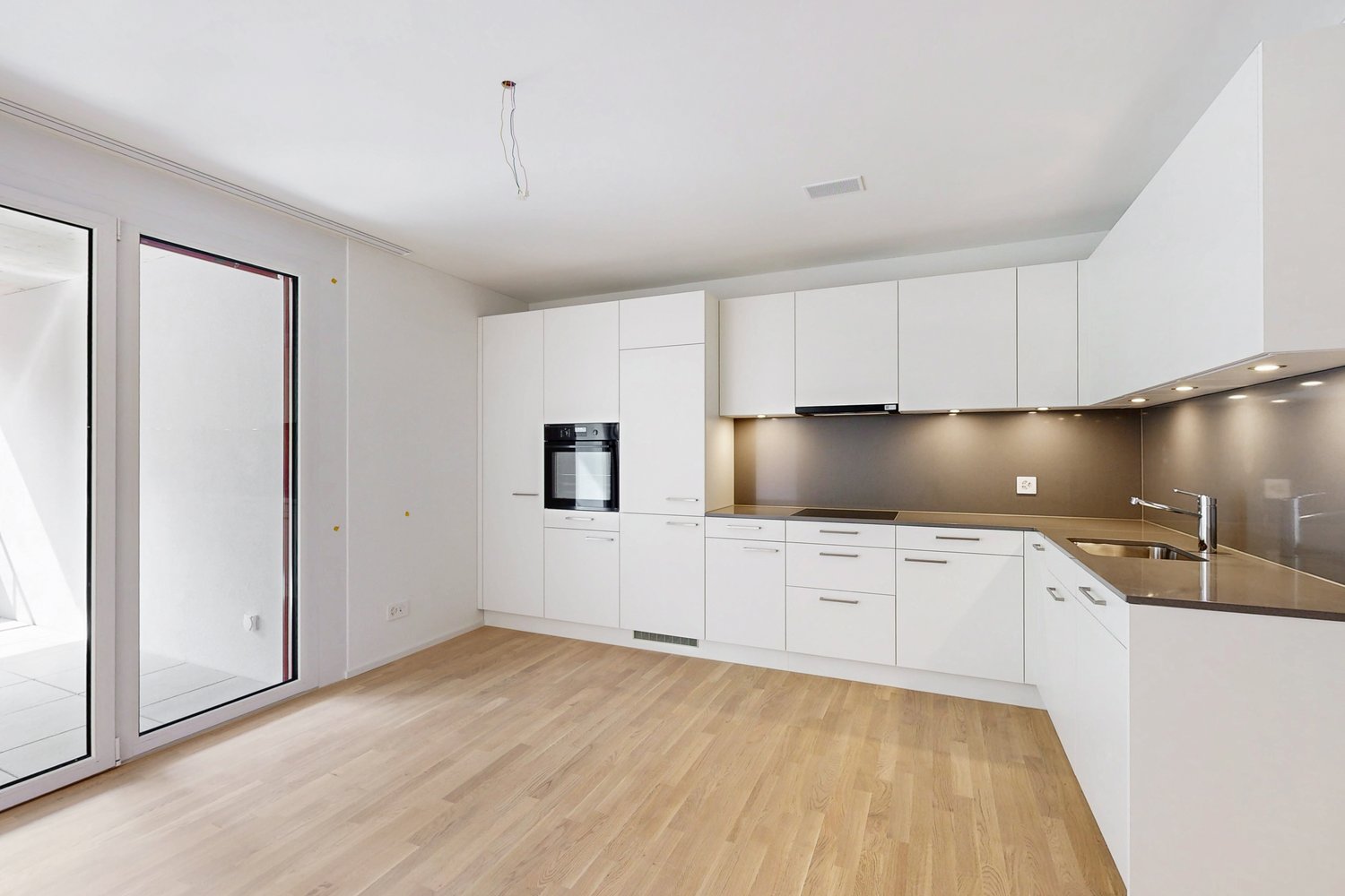 modern kitchen, white cabinets, wooden floors, open doorways, modern appliances, tiled walls, sliding glass doors