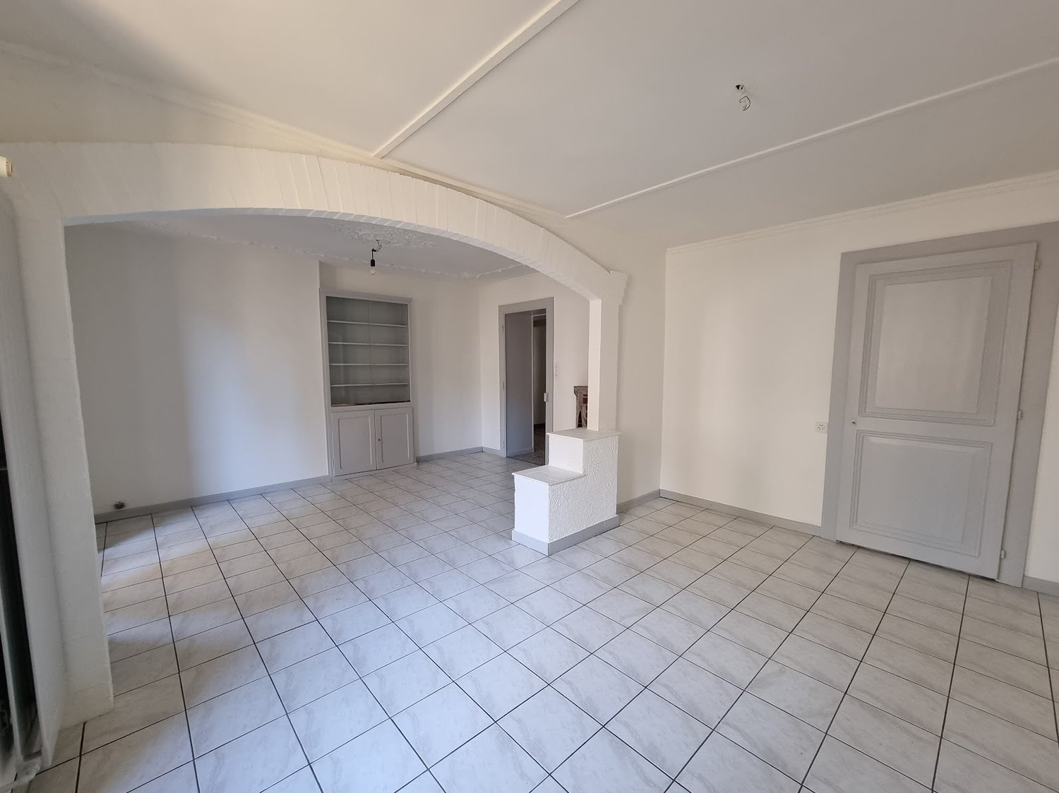 tiled floor, white walls, two doors, open doorway, window, cabinets