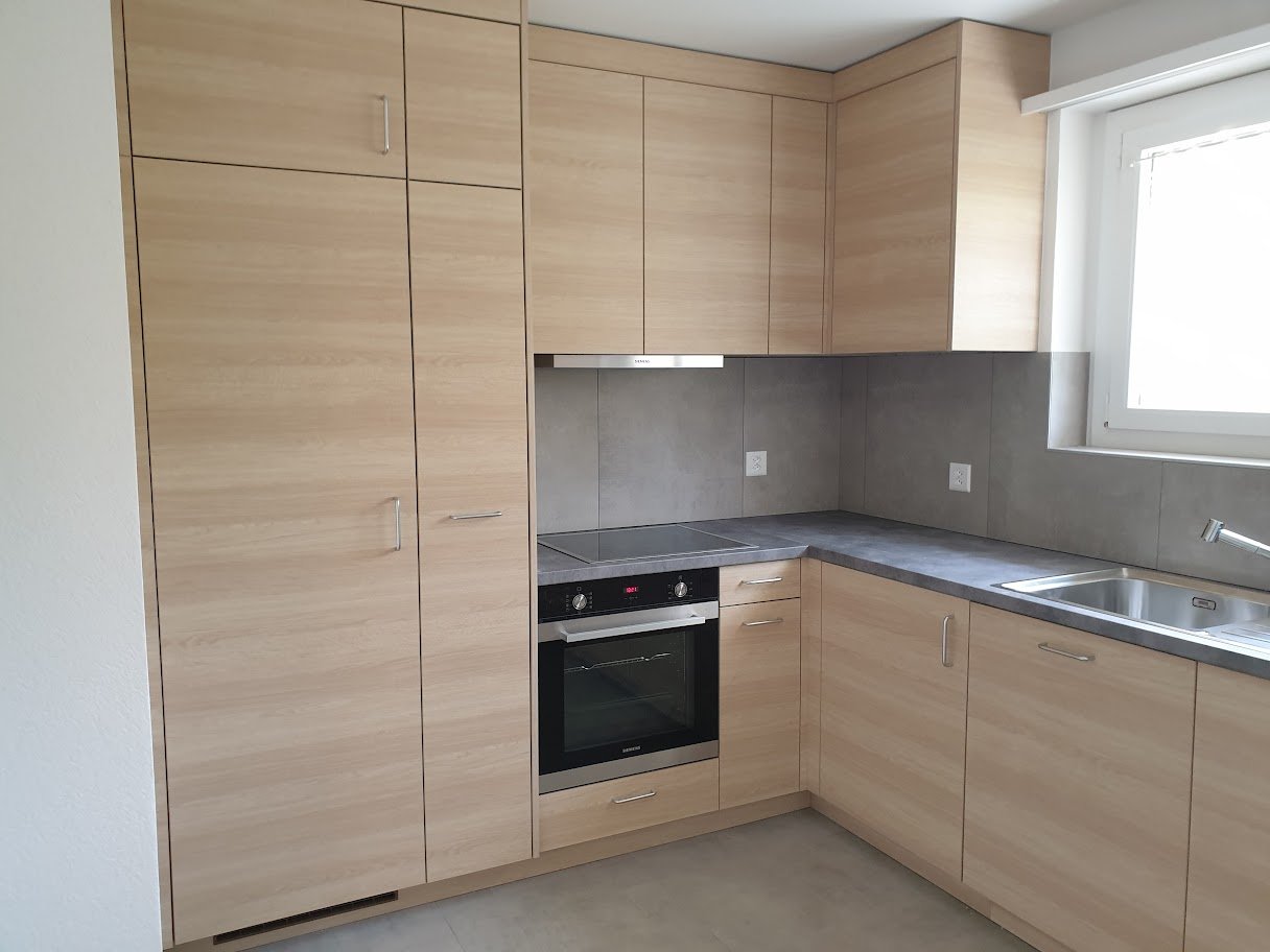 wooden cabinets, modern stove, stainless steel sink, power outlet, window