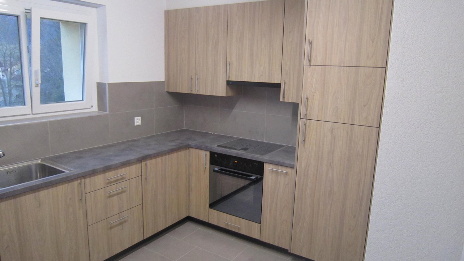 modern kitchen with wooden cabinets, grey tiled backsplash, stainless steel sink, electric stove, oven, window