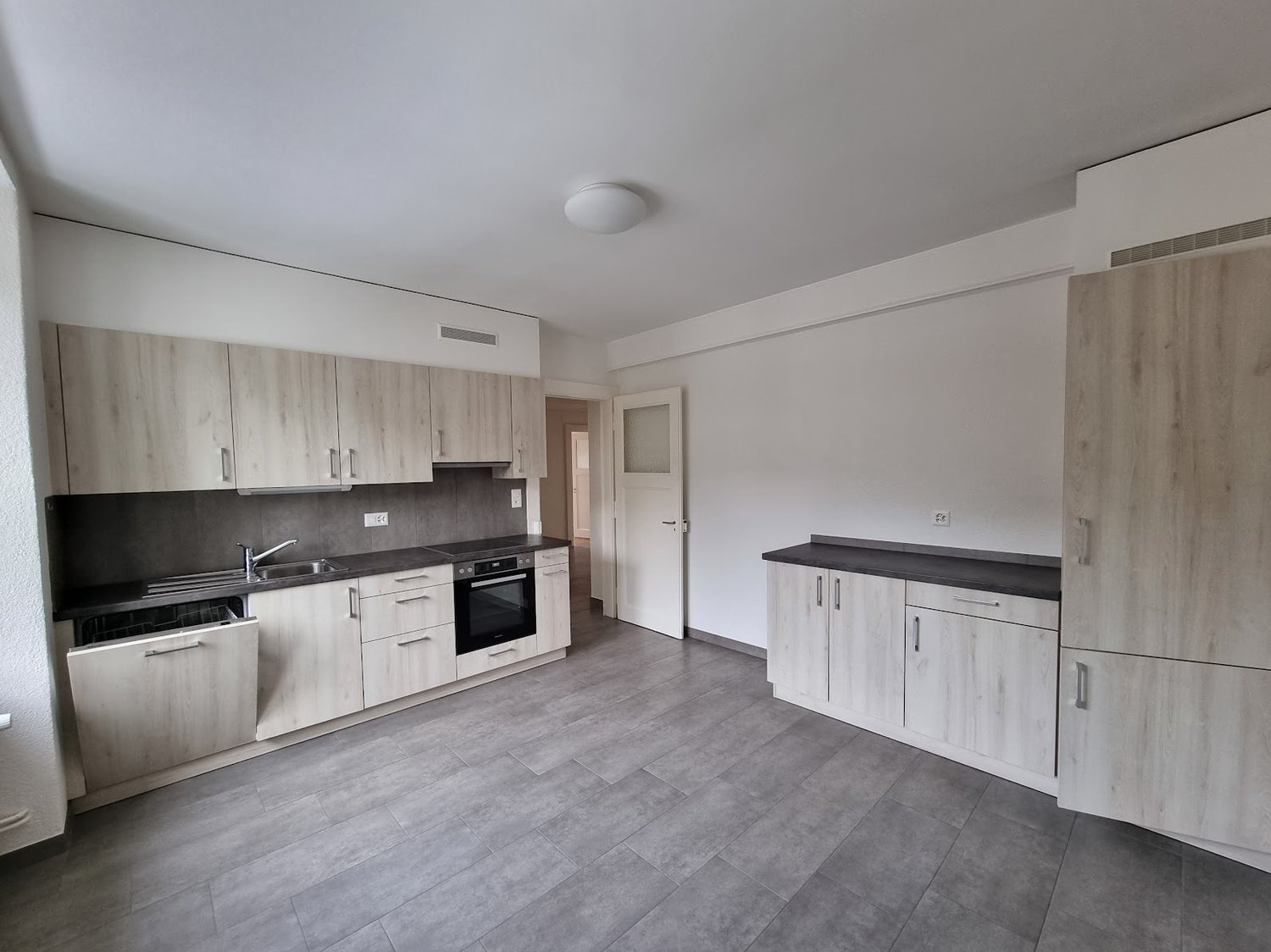 empty kitchen with cabinets, stove, sink, dishwasher, and counter with modern appliances