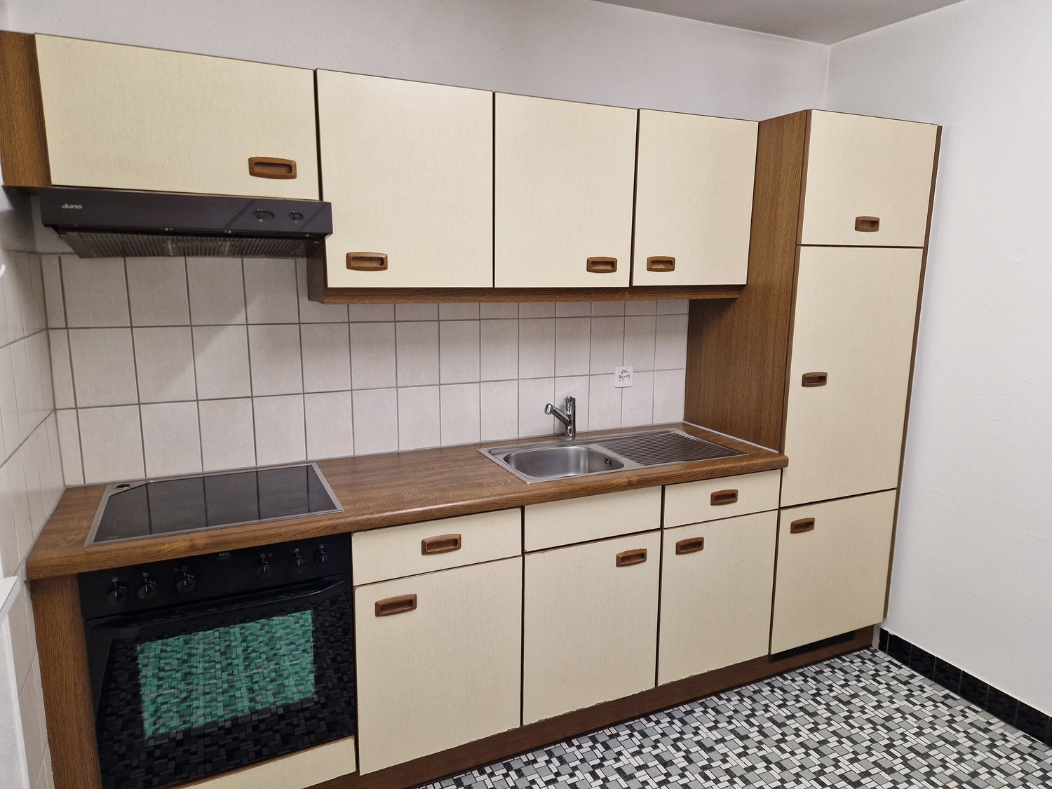 Fully equipped kitchen with beige cabinets, wooden countertops, built-in oven, and a dishwasher