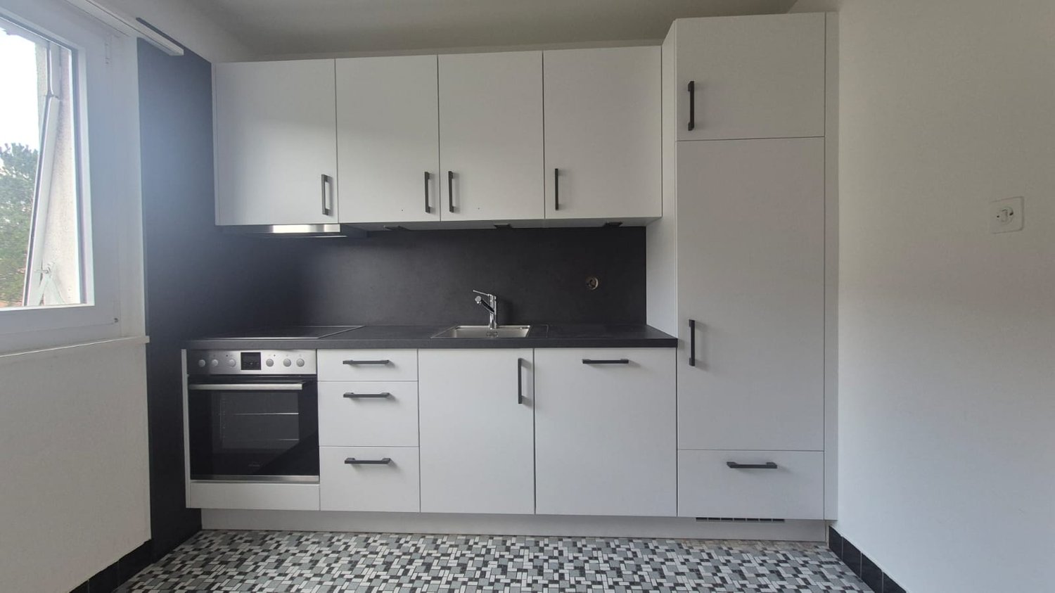 modern kitchen with integrated oven and dishwasher, white cabinets, black countertop, white floor
