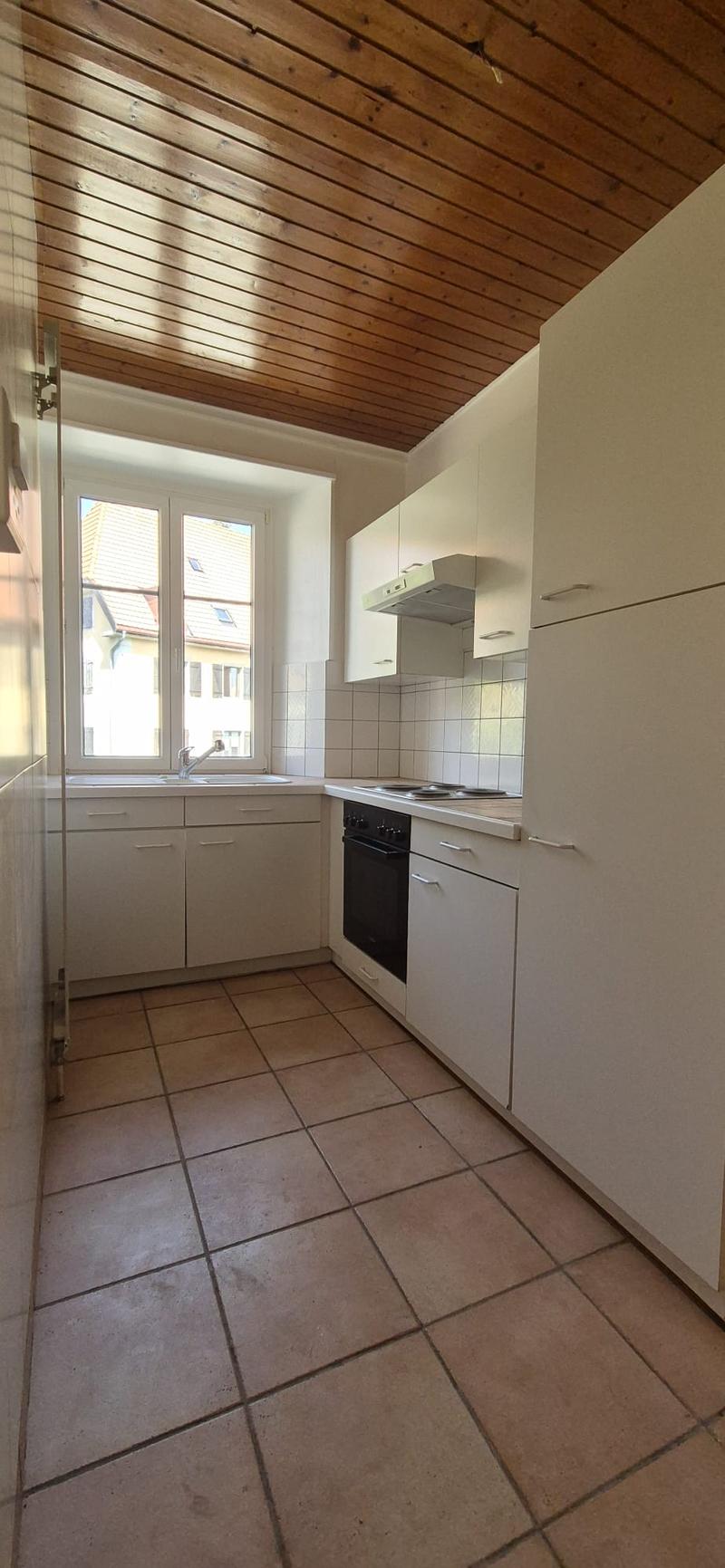 modern kitchen with white cabinets, tiled floor, gas stove, sink, dishwasher, washing machine