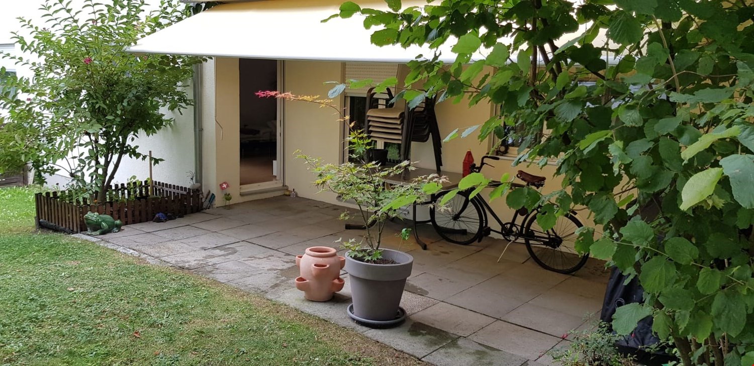 Terrace with outdoor seating, potted plants, bicycle parked, awning