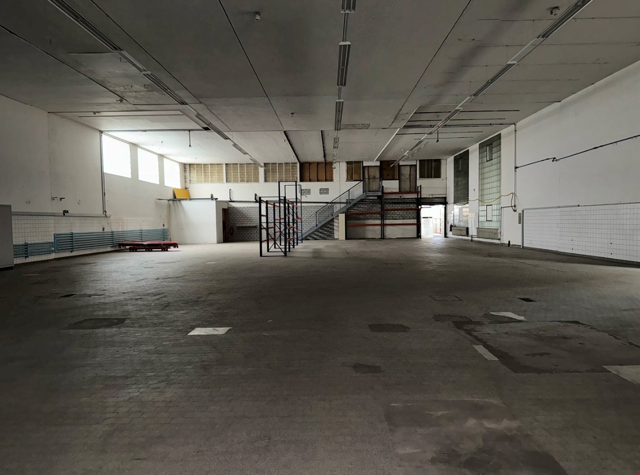 spacious interior, metal staircase, windows, tiled floor, white walls, electrical wires