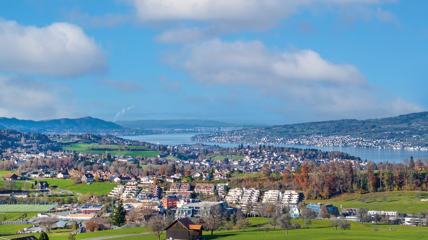House with lake view, mountains in the background, town in the distance