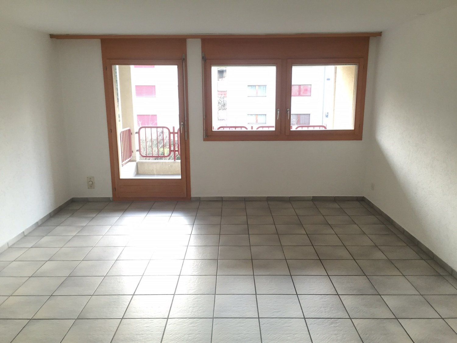 empty room, white tiles, wooden door, windows, balcony