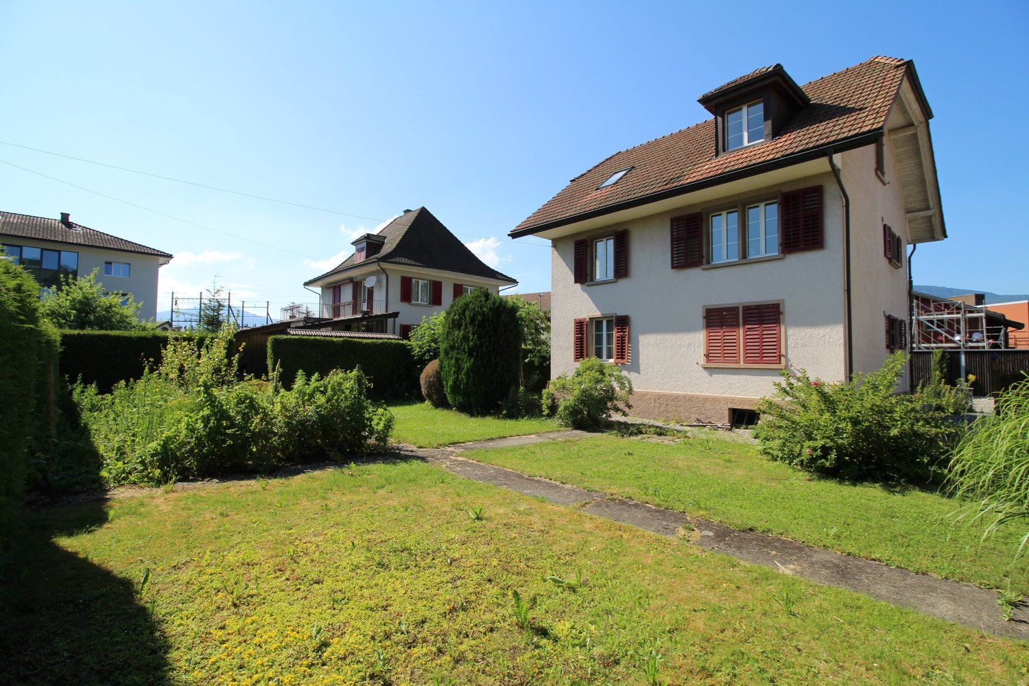 Two story house with a large garden in front