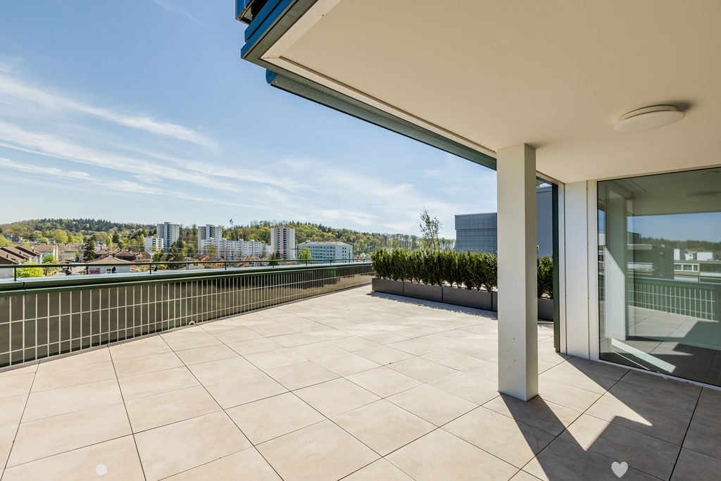 Tiled balcony, large glass doors, metal railings, large bushes, open view, high contrast shadows