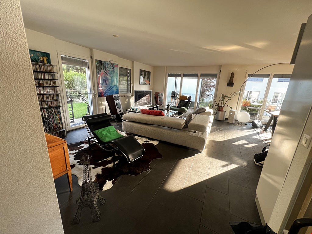 white couch, brown coffee table, modern design, tile flooring, glass doors to balcony, decorative items, plants, Eiffel tower model