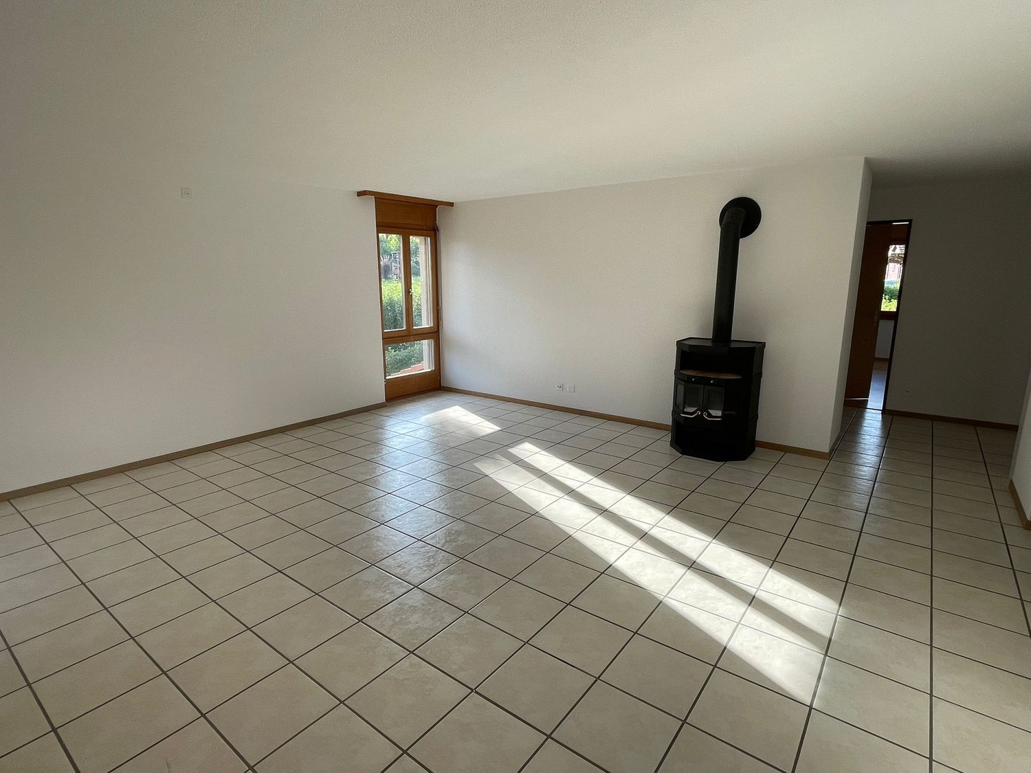 tiled floor, white walls, fireplace, sliding glass door, power outlet
