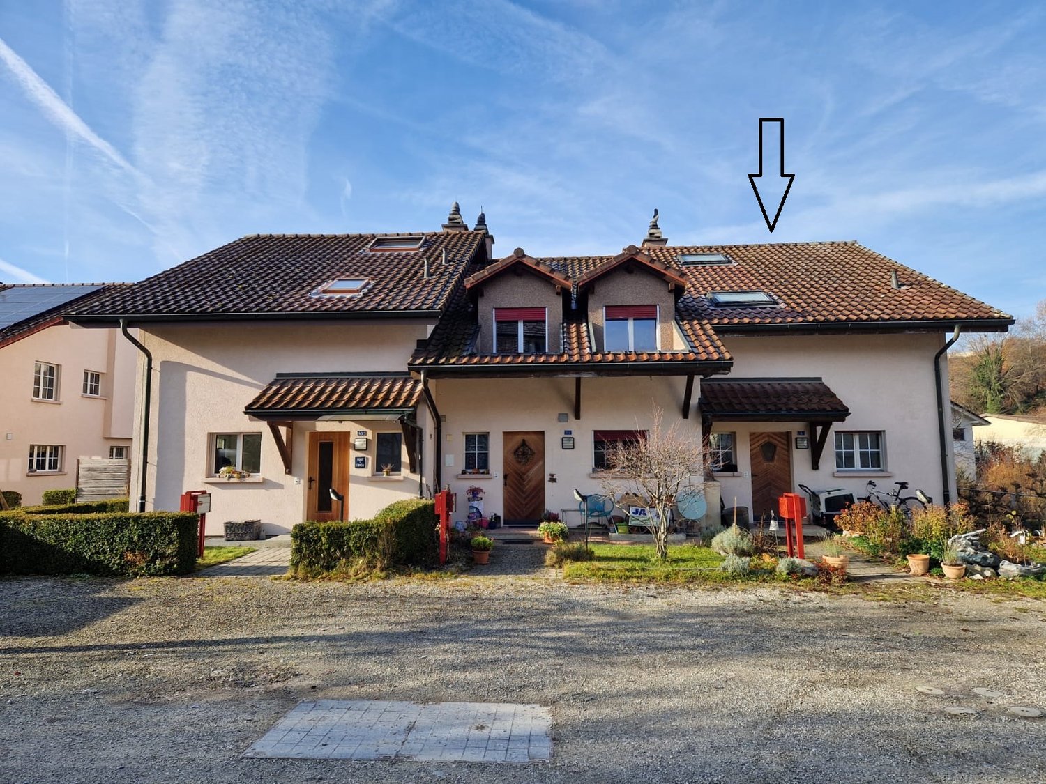 2 story semi-detached house, brown roof, red front door, paved driveway