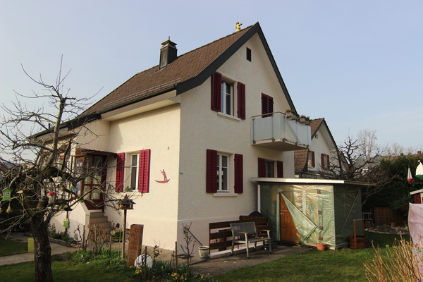 2 story house, white exterior, red shutters, brown roof, balcony, garden, bench, shed