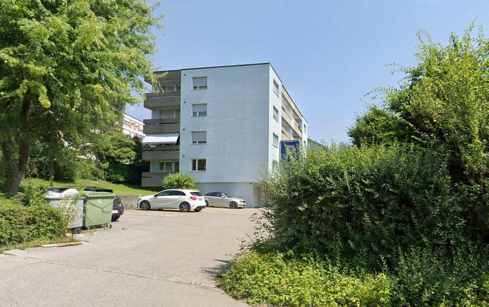 modern white house, 3 story, several windows, parking lot, green plants