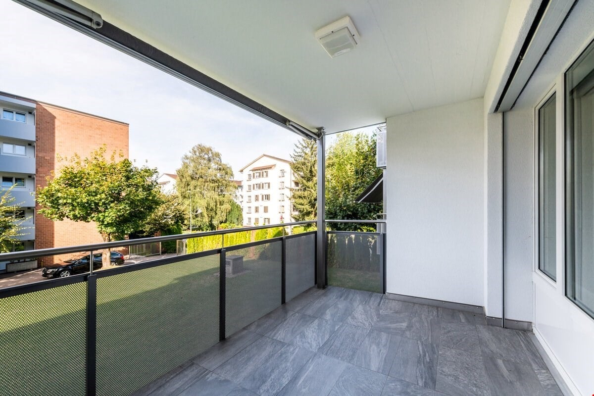 balcony, tiled floor, black fence, glass fence, black car parked