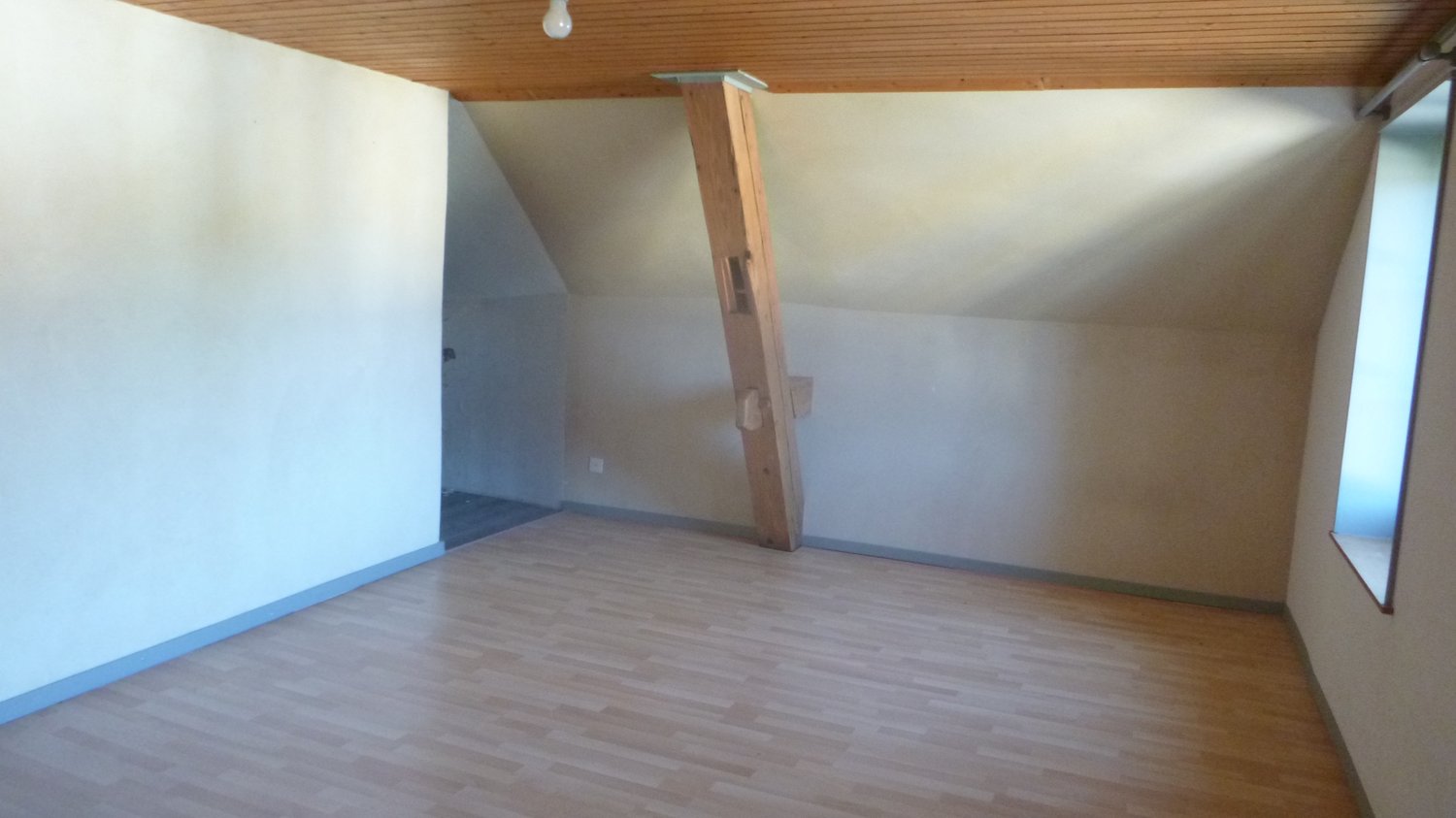 empty room, wooden beam, electrical outlet, wooden floor, windows, ceiling lamp