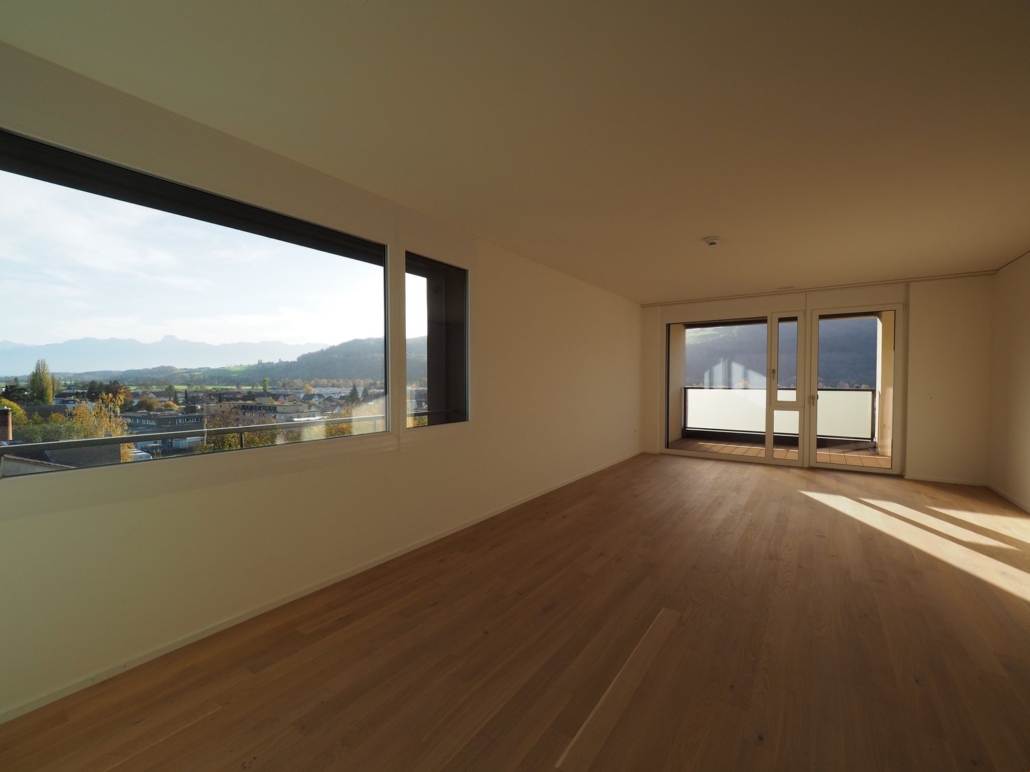 large windows, balcony, wooden floor, sliding glass doors