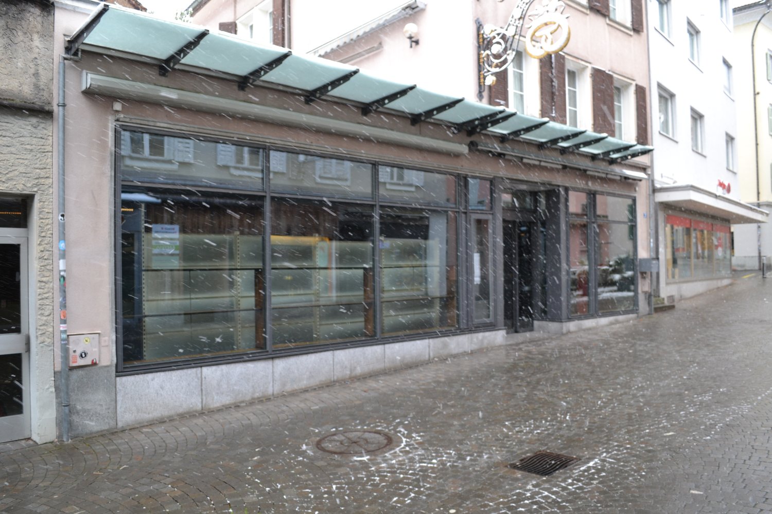 Facade of building with a canopy, glass windows, and signage.