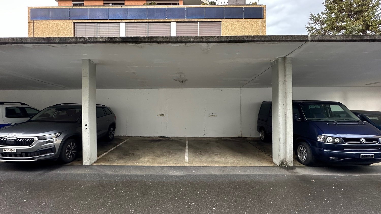 Underground car park with several parked cars and pillars