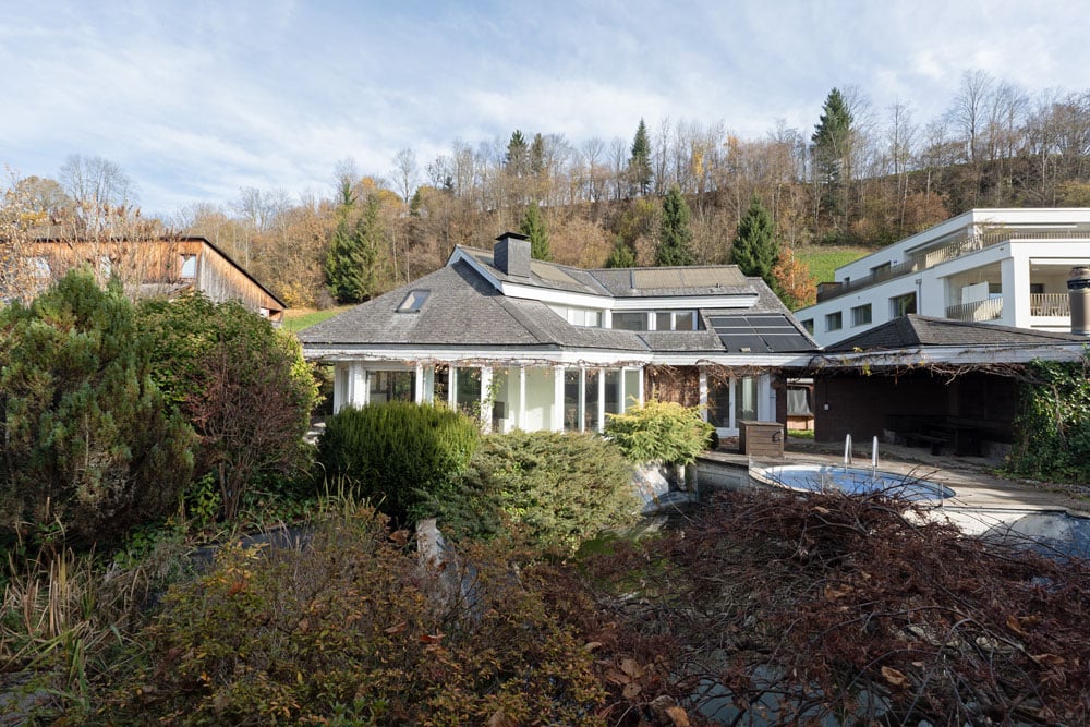 detached house, swimming pool, grey roof, surrounded by trees and shrubs