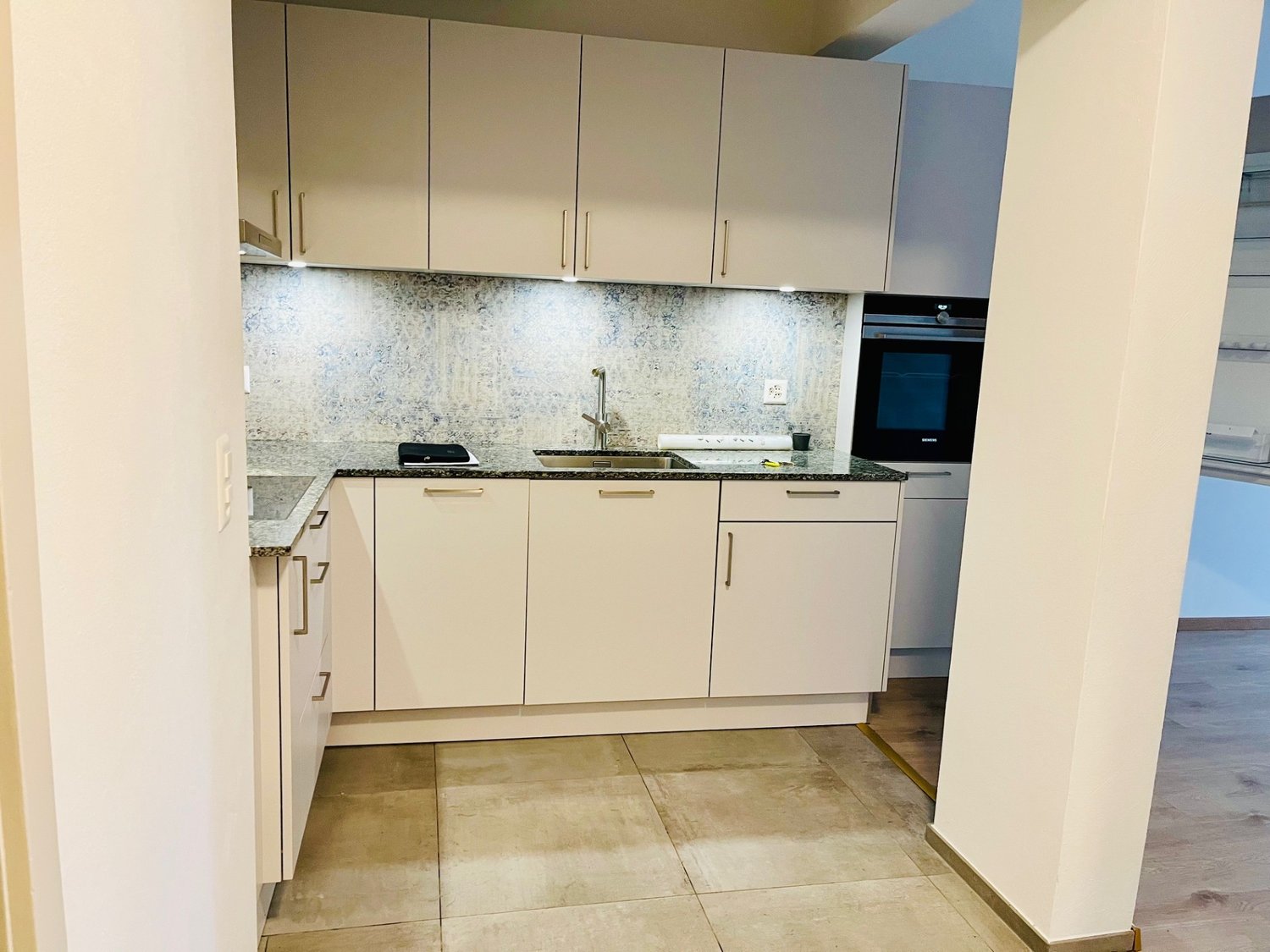 white cabinets, granite countertop, stainless steel sink, faucet, built-in oven and microwave