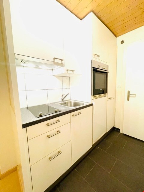 kitchen with white tiles, white cabinets, granite countertop, built-in oven, stove, sink, and tap
