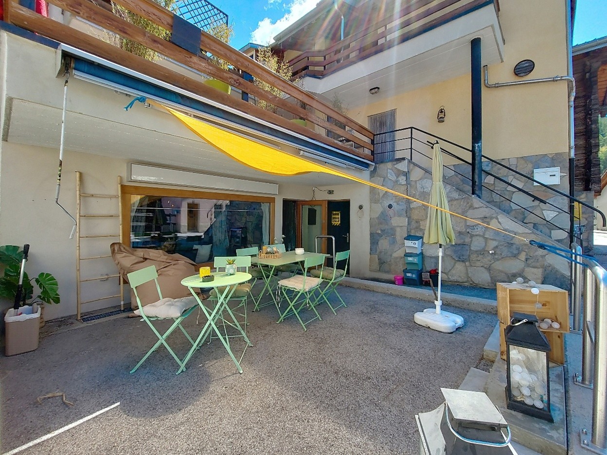 green folding chairs, table, stairs, balcony, awning, potted plants