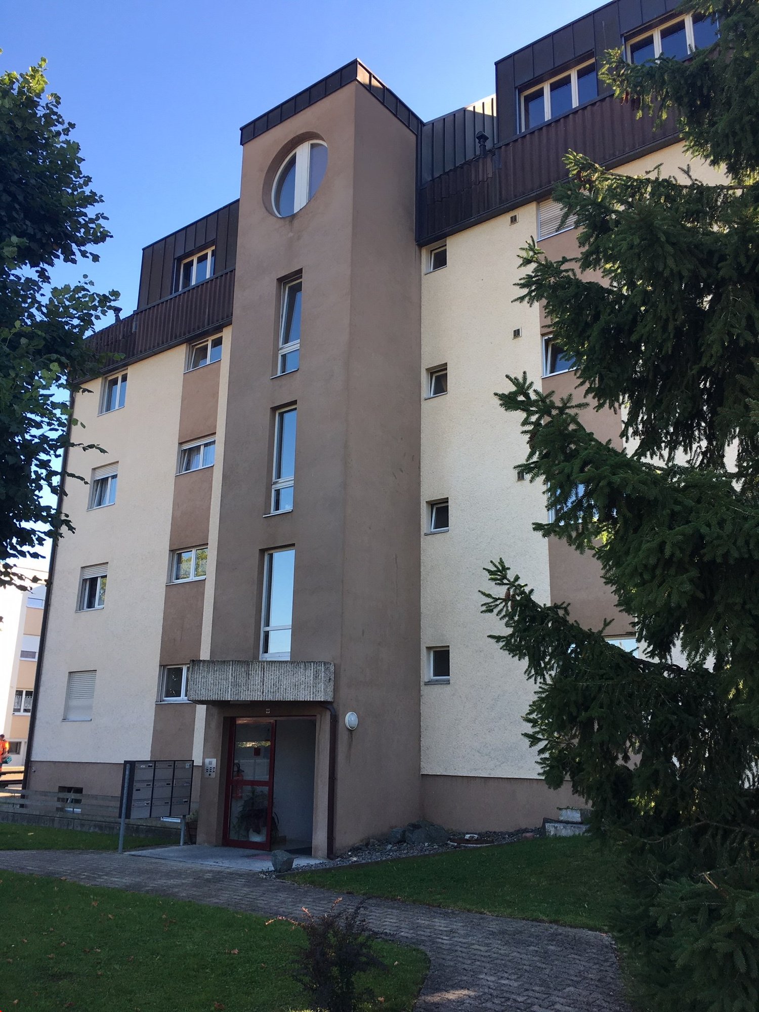 5 story building, red brick walls, glass windows, brown roofing, front entry