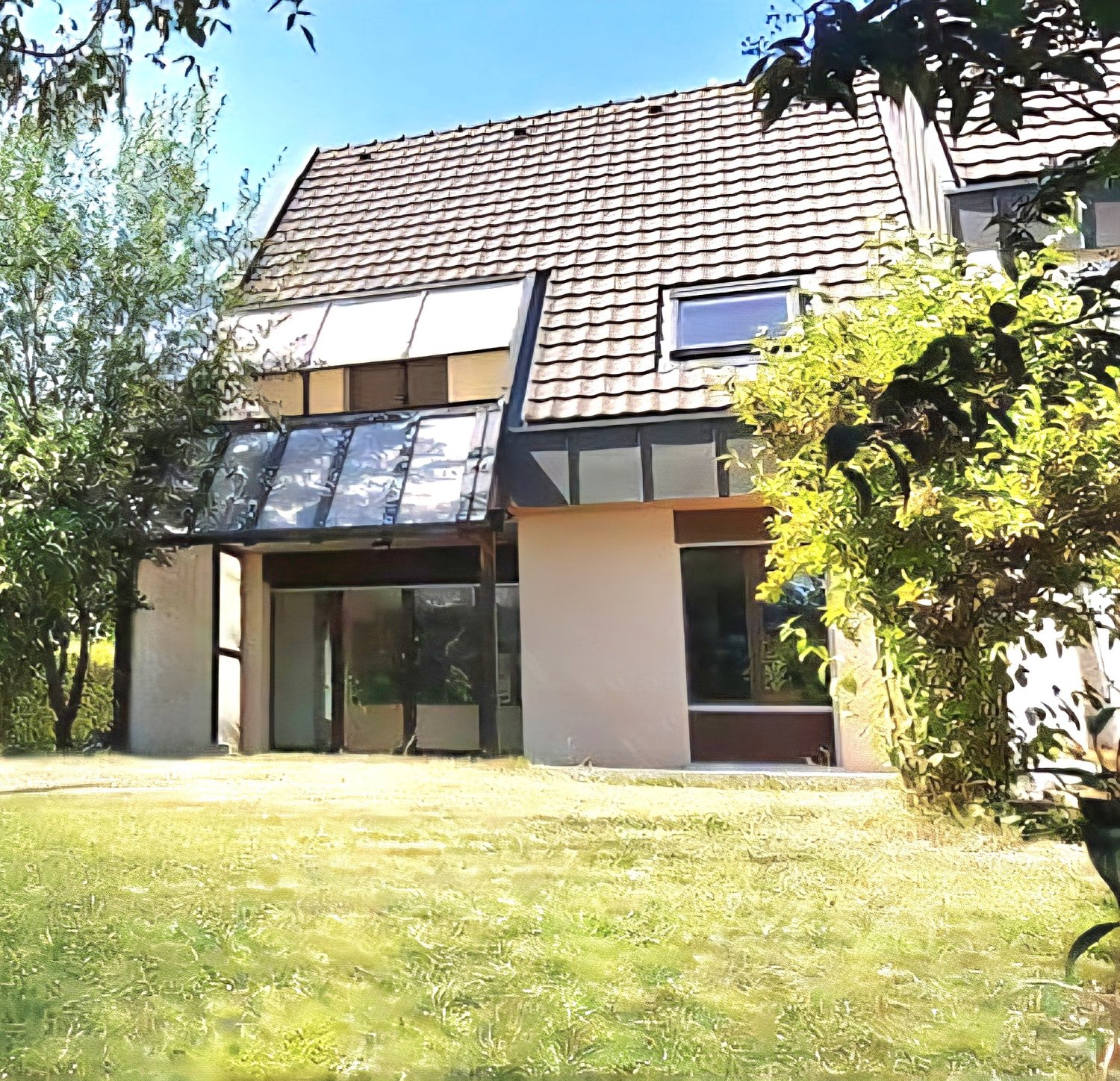Modern 2-story house, brick exterior, glass balcony, glass windows, large glass door at entrance, brown roof