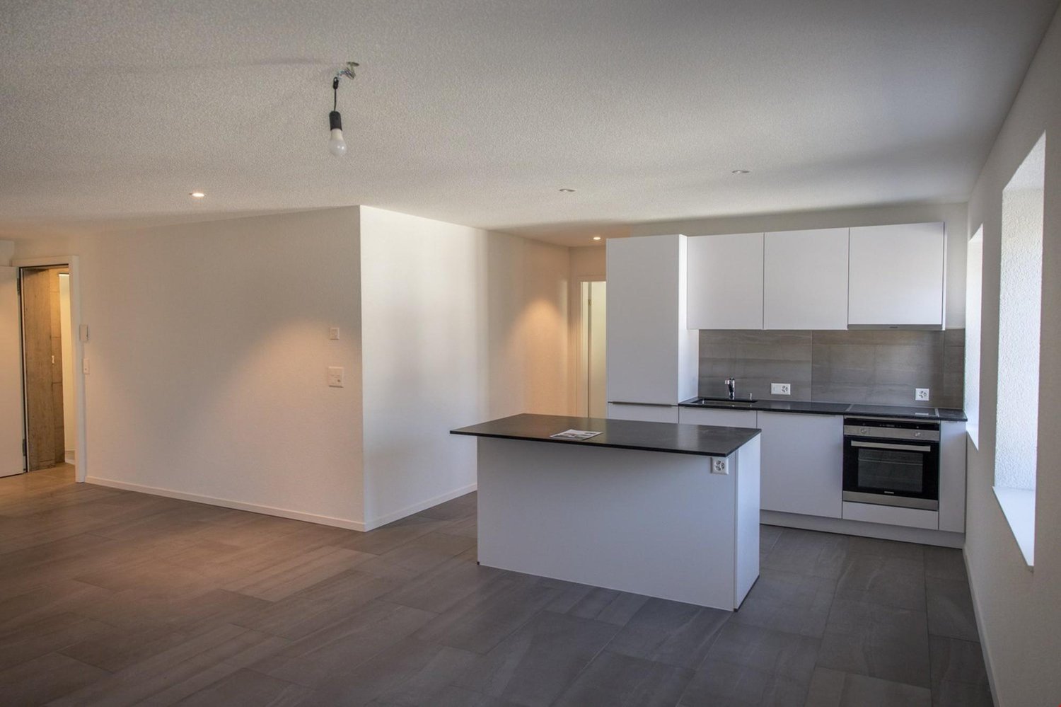 modern, minimalist kitchen with black countertop and white cabinets