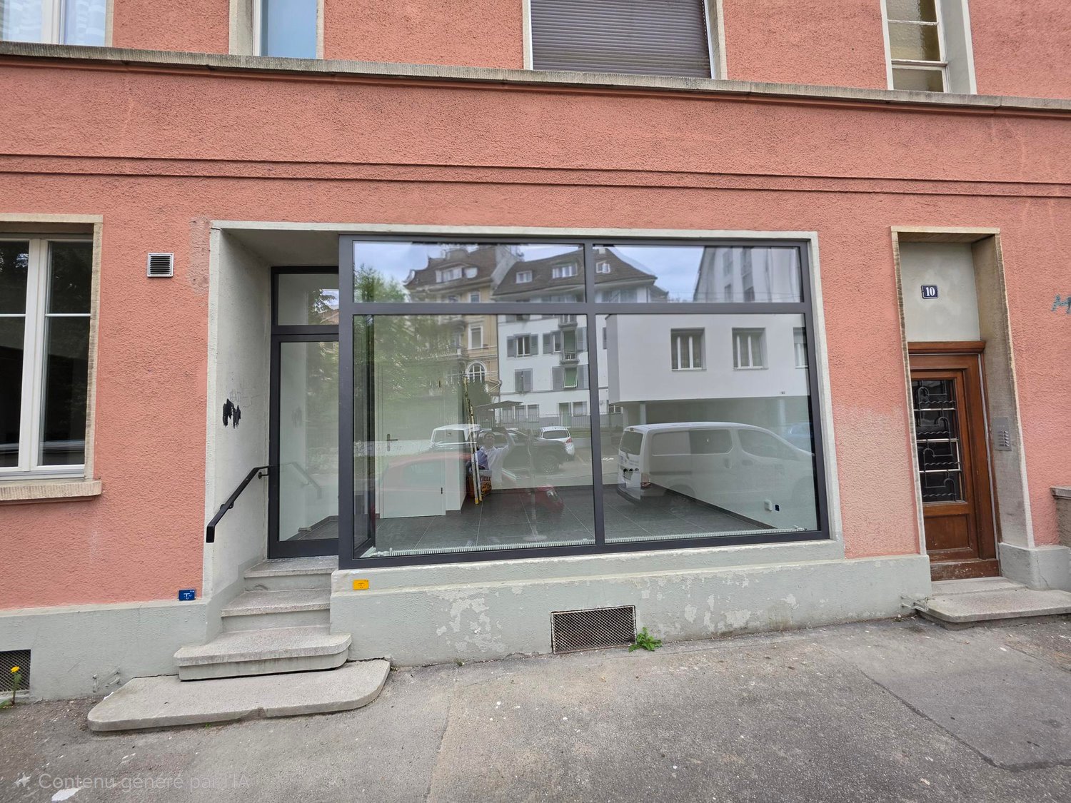 Pink building with glass entrance, steps leading up, large glass windows, number 10 on the door