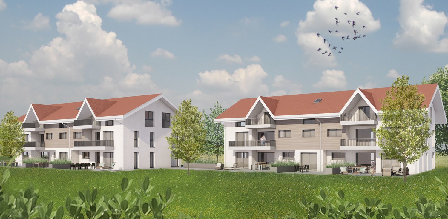 Two-story apartment buildings with red tile roofs, white exterior walls, and balconies. The buildings are surrounded by green grass and trees.