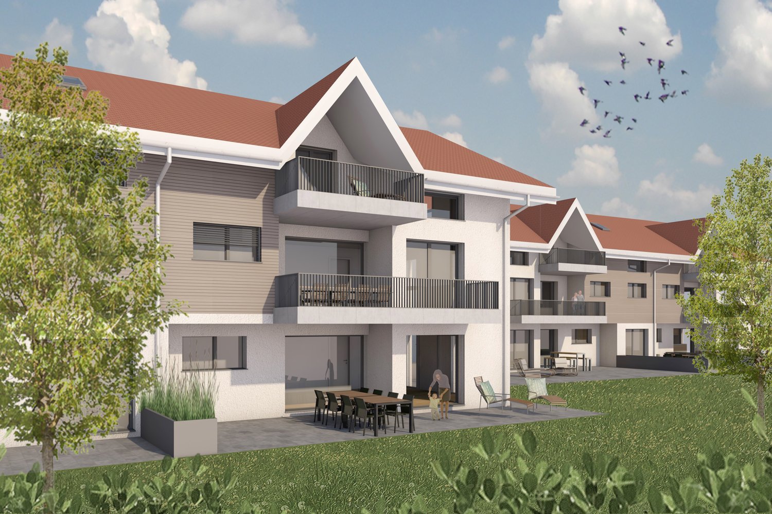 3-story apartment building with a modern, angular design. The building has a mix of gray and white exterior colors, with red-tiled roofs. There are balconies on some of the units, and the ground floor has a patio area with outdoor furniture. The building