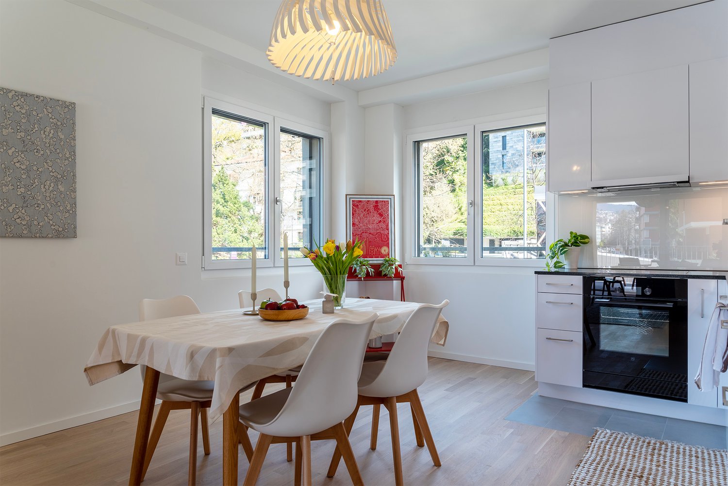 Dining room with a table, chairs, and a kitchen area with an oven and cabinets