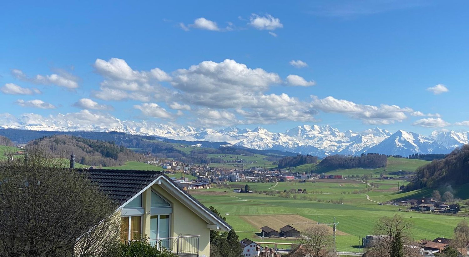 Detached house with a small balcony, yellow exterior, situated in a valley with mountain view