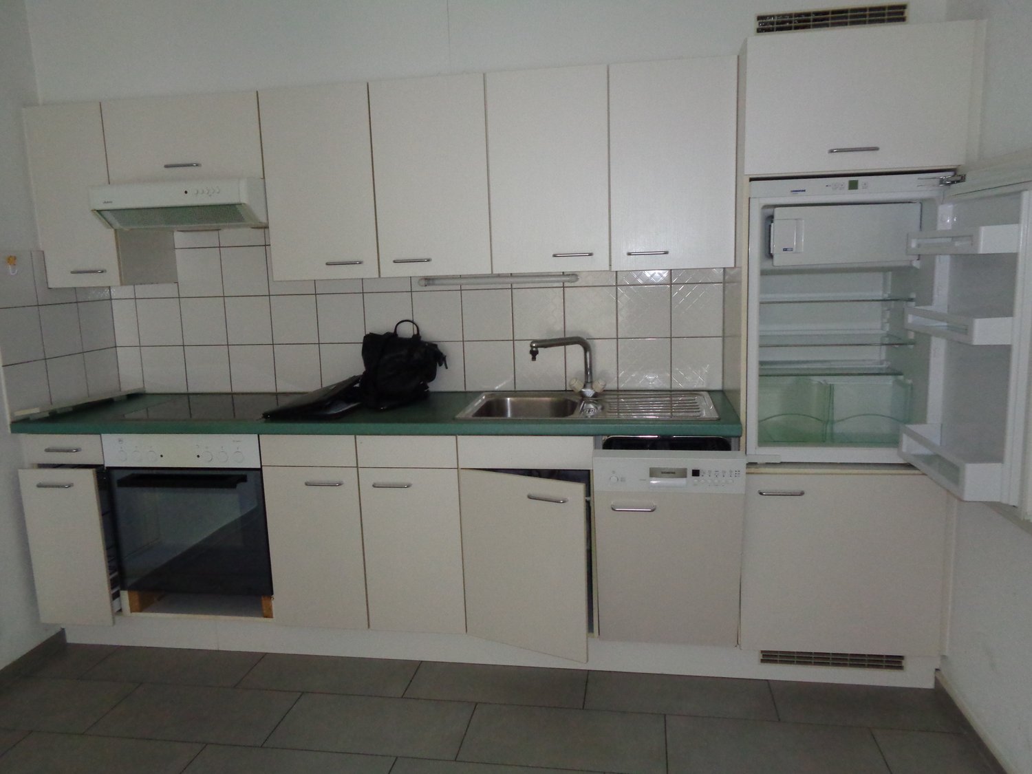 white cabinets, green countertop, stainless steel sink, dishwasher, refrigerator, oven, tiled walls
