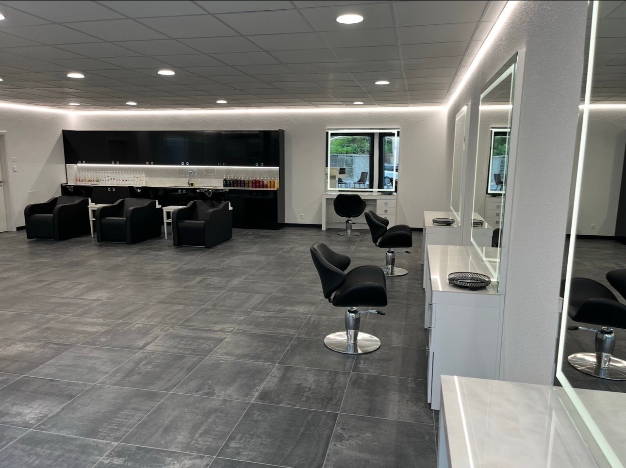 modern and clean salon with black seating and white countertops