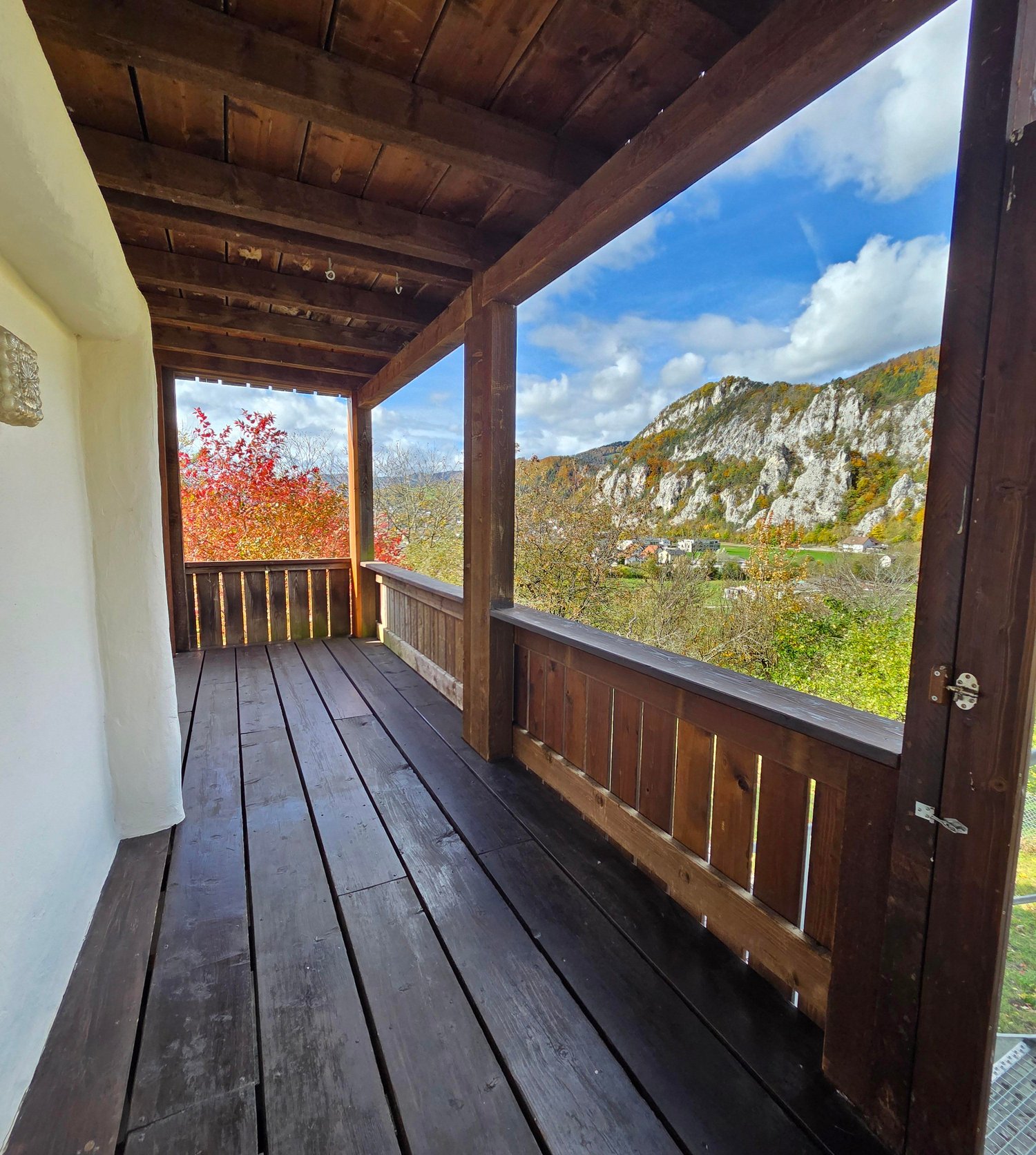 wooden floor, wooden beams ceiling, wooden balcony, large windows, mountain view