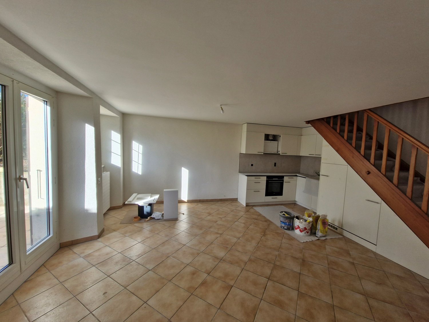 open kitchen, white cabinetries, tiled floor, glass door, stairs