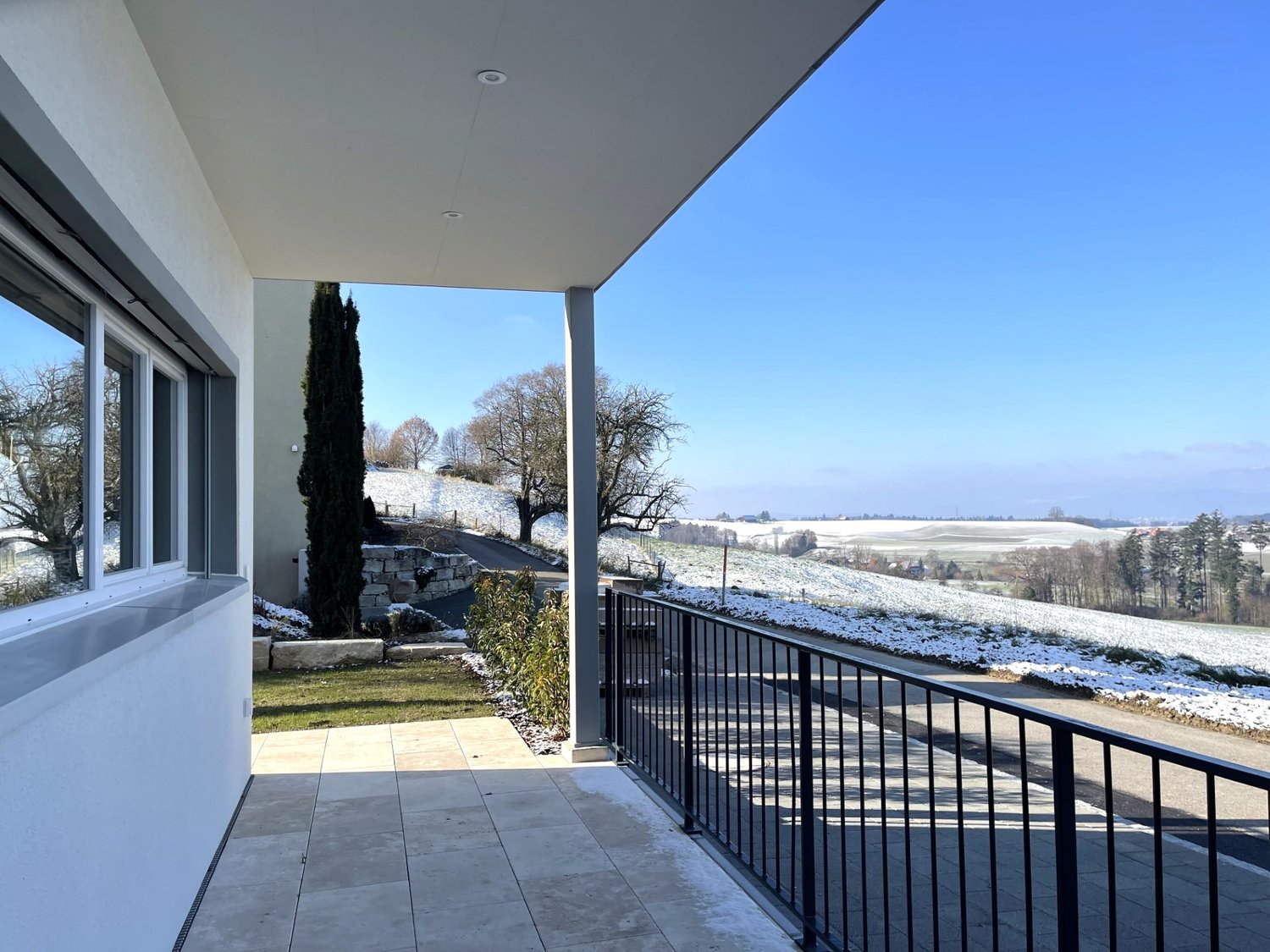 a balcony with a railing, overlooking a snowy landscape
