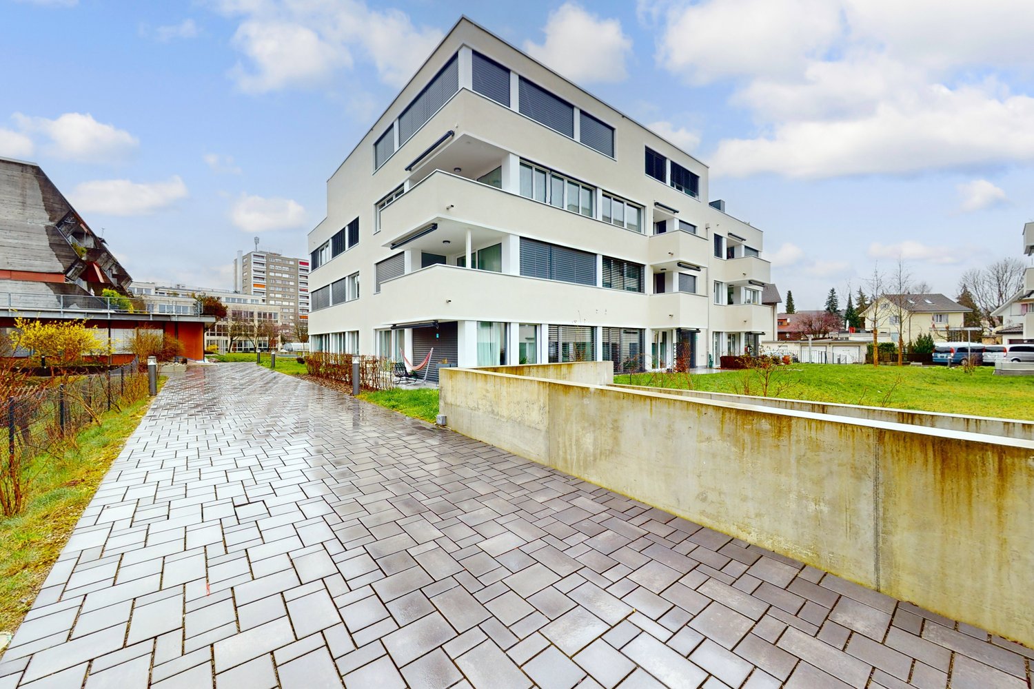 modern white apartment building, brick walk way, glass windows, balconies