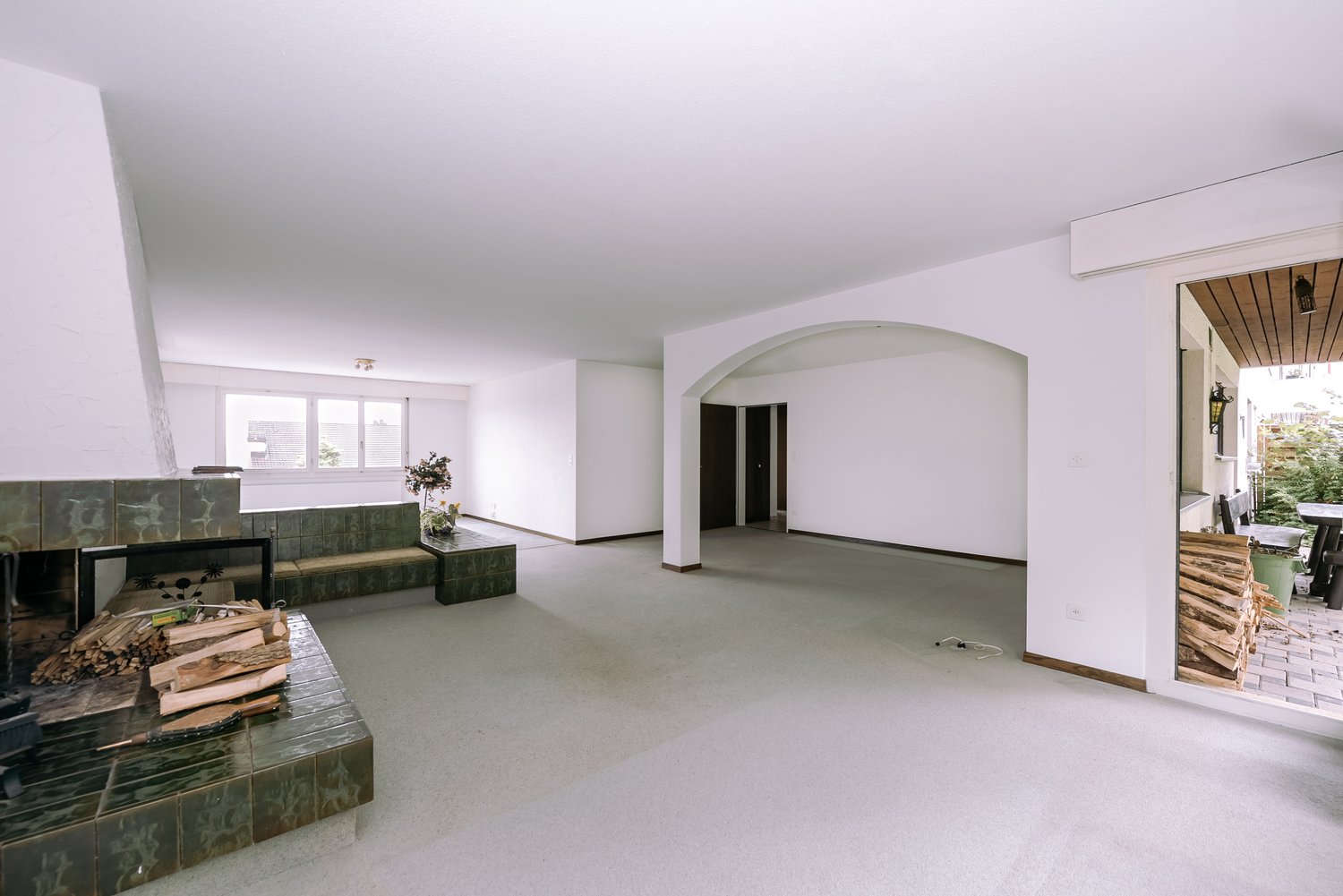 open space, fireplace, white walls, large windows, door to garden