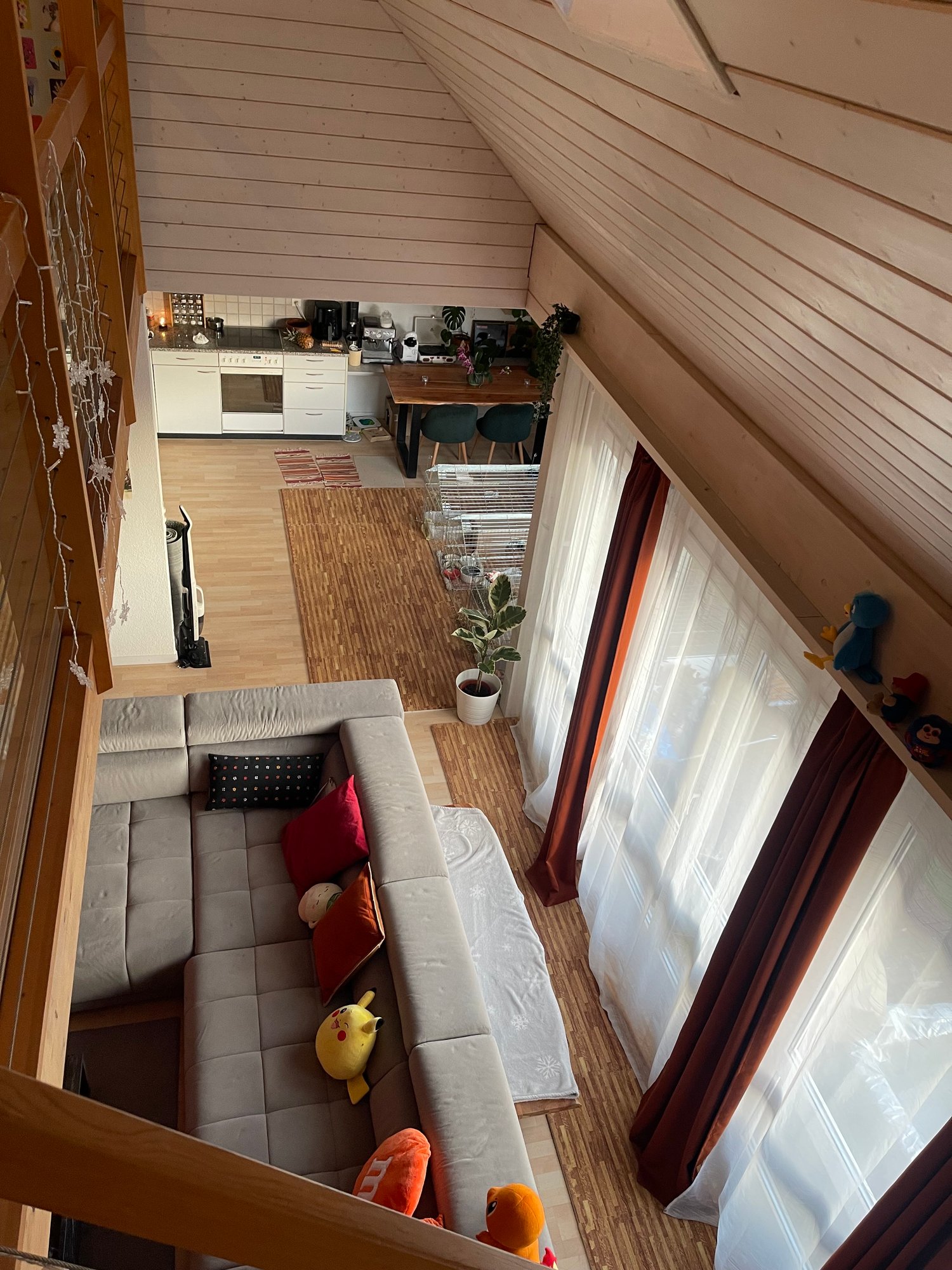 open floor plan, living room with a couch, kitchen, dining table, windows