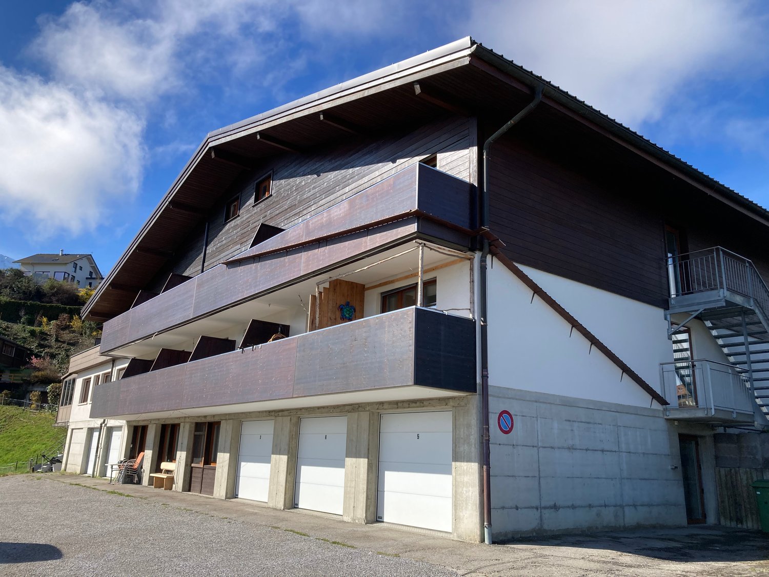Two story house, white and brown walls, garage, balcony