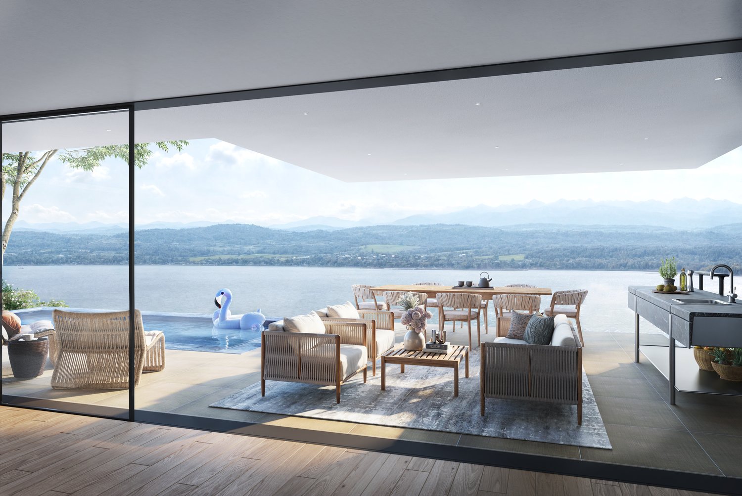 Spacious outdoor living area with large windows overlooking a scenic lake and mountains. The space features a dining table with chairs, comfortable lounge seating, and decorative elements like potted plants and inflatable swan. The overall design has a mo